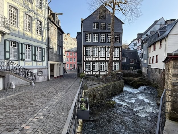 Historische Fachwerkhäuser und Fluss in einer malerischen Stadt.